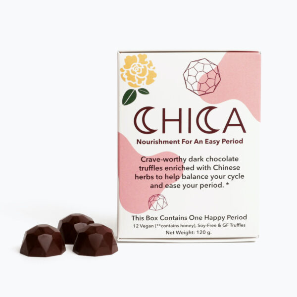 A box of Chica Chocolate stands in front of a white background, with three Chica Chocolate truffles sitting to the left of the box. The box says, "Nourishment for an easy period. Crave-worthy dark chocolate truffles enriched with Chinese herbs to hep balance your cycle and ease your period.* The box contains one happy period. 12 Vegan (but, contains honey), Soy-Free, and Gluten Free Truffles.