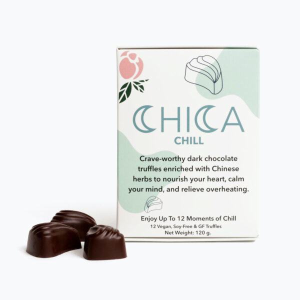 A box of Chica Chill stands in front of a white background, with three Chica Chill truffles grouped to the left of the box. The Chica Chill box says, "Crave-worthy dark chocolate truffles enriched with Chinese herbs to nourish your heart, calm your mind, and relieve overheating.* Enjoy up to 12 moments of Chill. 12 Vegan, Soy-Free, and Gluten Free truffles."